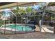 Backyard pool surrounded by a screen enclosure and lush tropical landscaping at 10632 Weybridge Dr, Tampa, FL 33626