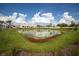 Picturesque view of the pond, landscaping, and a neighboring house in this beautiful residential community at 11221 Beach Walk Ne Way, St Petersburg, FL 33716