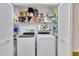 Washer and dryer inside open louvered closet with shelves for supplies in laundry area at 11430 94Th St, Largo, FL 33773