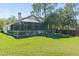 Landscaped backyard with a covered patio area and white fence at 12227 Glencliff Cir, Tampa, FL 33626