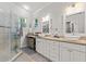 Bright bathroom with a glass shower, granite countertop, dual vessel sinks, updated vanity, and modern fixtures at 12227 Glencliff Cir, Tampa, FL 33626