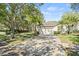 Inviting home featuring a spacious driveway, well-maintained lawn, mature trees, and manicured hedges adding to its curb appeal at 12227 Glencliff Cir, Tampa, FL 33626