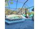 Outdoor hot tub surrounded by a screened enclosure with outdoor seating and views of the yard and sky at 12227 Glencliff Cir, Tampa, FL 33626