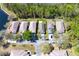 An aerial view of single Gathering homes backing up to a heavily wooded area and a pond at 12652 Chenwood Ave, Hudson, FL 34669