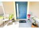 Cozy front porch with stylish blue door, plant decor, and a 'Home' welcome mat at 12652 Chenwood Ave, Hudson, FL 34669