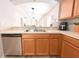 Kitchen features stainless steel dishwasher, solid surface countertops, and a view to the living area at 12652 Chenwood Ave, Hudson, FL 34669