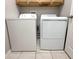 Functional laundry room with standard washer and dryer units, tiled flooring at 12652 Chenwood Ave, Hudson, FL 34669