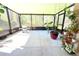 Enclosed patio with concrete floor, dining table, potted plants and view of trees at 12652 Chenwood Ave, Hudson, FL 34669