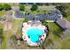 Aerial view of a clover shaped community pool with lounging area, convenient parking and a nearby playground at 12652 Chenwood Ave, Hudson, FL 34669