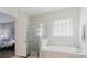 Bright bathroom with large window, walk-in shower, and soaking tub with marble surround at 12749 Weatherstone Dr, Spring Hill, FL 34609