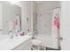 Bathroom with white vanity, toilet, shower-tub combination with marble-patterned tile, and flamingo shower curtain at 12749 Weatherstone Dr, Spring Hill, FL 34609