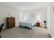 Comfortable bedroom with neutral walls, carpet floors, and a queen-sized bed with light and airy bedding at 12749 Weatherstone Dr, Spring Hill, FL 34609