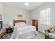 Bright bedroom with a queen bed featuring white linens and flamingo pattern, ceiling fan, and neutral paint at 12749 Weatherstone Dr, Spring Hill, FL 34609