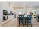 Bright kitchen features white cabinets, stainless steel appliances, large island and breakfast bar with stylish blue chairs at 12749 Weatherstone Dr, Spring Hill, FL 34609