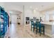 Open-concept kitchen featuring white cabinetry, a breakfast bar with seating, and stylish wood-look tile flooring at 12749 Weatherstone Dr, Spring Hill, FL 34609
