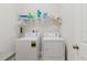 Functional laundry room with washer, dryer, and storage shelf at 12749 Weatherstone Dr, Spring Hill, FL 34609