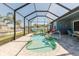 Screen-enclosed pool area featuring a uniquely designed pool, comfortable lounge seating, and lush landscaping for relaxation at 12749 Weatherstone Dr, Spring Hill, FL 34609