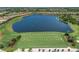 Aerial view of lush driving range with lake and golf course community in the background at 12835 Sorrento Way, Bradenton, FL 34211