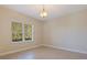 Bedroom with a large window offering views of the lush greenery outside and neutral walls at 13574 Circa Crossing Dr, Lithia, FL 33547