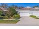 Charming home showcasing a manicured lawn, mature trees, and an attached two-car garage, reflecting a peaceful suburban setting at 13574 Circa Crossing Dr, Lithia, FL 33547