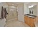 Bright bathroom featuring walk-in shower, granite counters, and neutral tile flooring at 140 Brightwater Dr # 1, Clearwater Beach, FL 33767