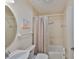 Cozy bathroom featuring a shower with curtain, round mirror, and stylish decor at 140 Brightwater Dr # 1, Clearwater Beach, FL 33767