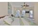 Cozy bedroom with tropical accents, ceiling fan, and natural light at 140 Brightwater Dr # 1, Clearwater Beach, FL 33767