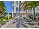 Coastal townhome boasts a brick-paved driveway, garage, and lush tropical landscaping at 140 Brightwater Dr # 1, Clearwater Beach, FL 33767