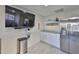 A modern living room featuring a stainless refrigerator, granite counters, and a wall-mounted TV at 140 Brightwater Dr # 1, Clearwater Beach, FL 33767