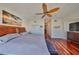 Bright primary bedroom featuring wooden floors, ceiling fan, and a beach themed painting at 140 Brightwater Dr # 1, Clearwater Beach, FL 33767