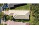 Aerial view of a tan-roofed home featuring a brick driveway surrounded by tropical trees at 15908 Cobble Mill Dr, Wimauma, FL 33598
