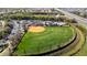 Aerial view showcasing a baseball field surrounded by trees and parking at 15908 Cobble Mill Dr, Wimauma, FL 33598