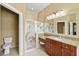 Bathroom with granite countertop vanity, ornate mirrors, and shower with patterned glass at 15908 Cobble Mill Dr, Wimauma, FL 33598