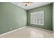 Bedroom features light-green walls, tile flooring, a baseboard, and a single window with shutters at 15908 Cobble Mill Dr, Wimauma, FL 33598