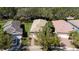 A well-maintained home featuring a tile roof, lush landscaping, and a brick driveway at 15908 Cobble Mill Dr, Wimauma, FL 33598