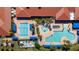 Aerial view showcasing multiple community pools, palm trees, and lounge areas, enhancing the resort-style atmosphere at 15908 Cobble Mill Dr, Wimauma, FL 33598