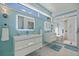 Bright bathroom features modern sinks, a walk-in shower, and blue accents at 173 1St W St, Tierra Verde, FL 33715
