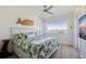 Inviting bedroom with views, featuring palm-themed bedding, a wooden whale decoration, and contemporary ceiling fan at 173 1St W St, Tierra Verde, FL 33715
