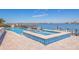 Waterfront pool with jacuzzi, stone deck, and chairs overlooking the bay offers a luxurious outdoor retreat at 173 1St W St, Tierra Verde, FL 33715