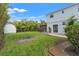 A spacious backyard with a white house, green lawn, landscaping, and outdoor seating at 209 17Th N Ave, St Petersburg, FL 33704