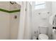 Bathroom featuring a shower with green trim and white tile, toilet, and fixtures at 209 17Th N Ave, St Petersburg, FL 33704