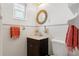 Bright bathroom with a dark wood vanity, white tile, and stylish round mirror at 209 17Th N Ave, St Petersburg, FL 33704