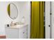 Chic bathroom with white vanity, round mirror, and a storage curtain at 209 17Th N Ave, St Petersburg, FL 33704