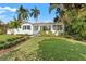 Charming white home featuring a well-manicured lawn, lush landscaping, and inviting curb appeal at 209 17Th N Ave, St Petersburg, FL 33704