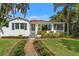 Inviting white home featuring a manicured lawn, lush landscaping, and a charming front entrance at 209 17Th N Ave, St Petersburg, FL 33704