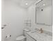 Well-lit bathroom featuring marble countertop, modern gold fixtures, and storage shelf at 209 Ne Lincoln N Cir # 105, St Petersburg, FL 33702