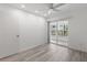 A light-filled bedroom with hardwood floors and glass sliding doors leading to the outside at 209 Ne Lincoln N Cir # 105, St Petersburg, FL 33702
