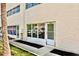 View of the building exterior showing unit 105A with a sliding glass door and tidy landscaping at 209 Ne Lincoln N Cir # 105, St Petersburg, FL 33702