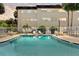 Community pool surrounded by fencing with lounge chairs and tropical landscaping at 209 Ne Lincoln N Cir # 105, St Petersburg, FL 33702