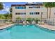 Community pool with lounge chairs, tables, and umbrellas providing a relaxing outdoor space at 209 Ne Lincoln N Cir # 105, St Petersburg, FL 33702